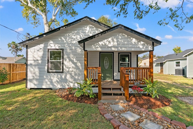 bungalow-style house featuring a front yard, cooling unit, and covered porch