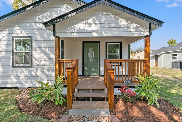 view of front facade featuring a front yard, a porch, and cooling unit