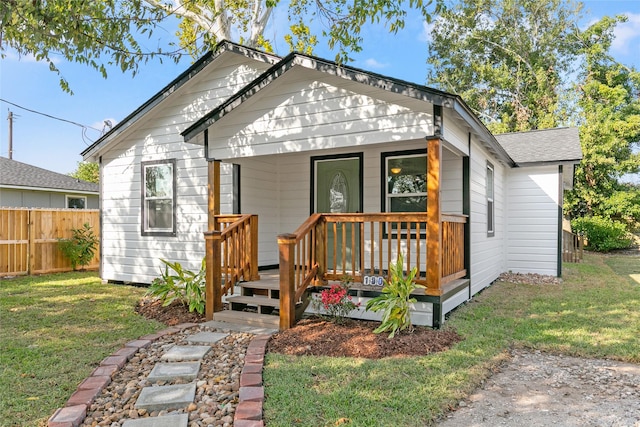 bungalow with covered porch and a front yard