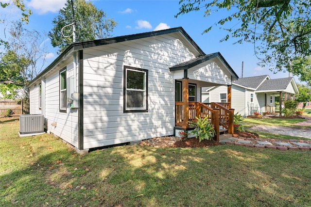 view of front of home featuring central AC unit and a front yard