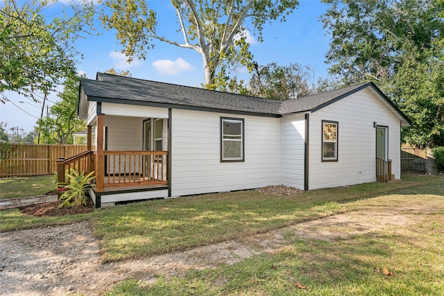 rear view of house featuring a yard