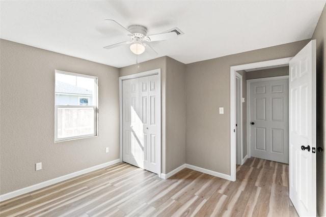 unfurnished bedroom featuring light wood-type flooring, a closet, and ceiling fan