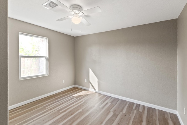 empty room with ceiling fan and light hardwood / wood-style flooring