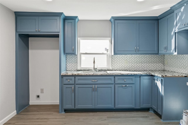 kitchen with backsplash, light stone counters, sink, and dark hardwood / wood-style floors