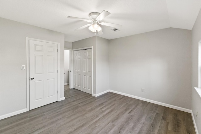 unfurnished bedroom featuring ceiling fan, a closet, lofted ceiling, and hardwood / wood-style flooring