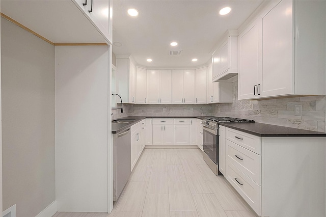 kitchen featuring appliances with stainless steel finishes, backsplash, white cabinetry, and sink