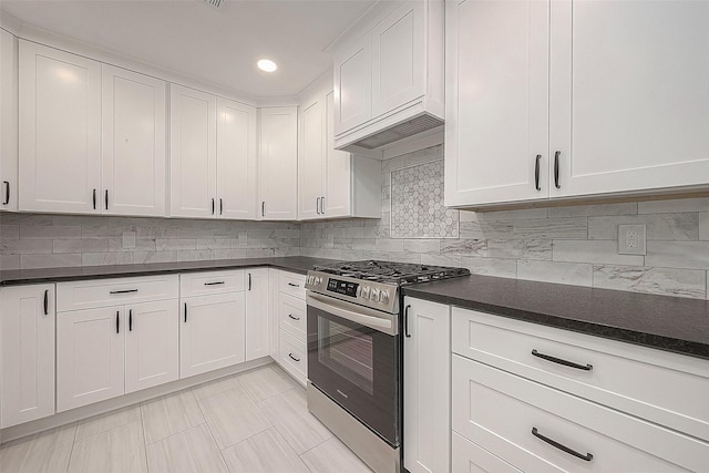 kitchen featuring decorative backsplash, white cabinets, light tile patterned floors, and stainless steel range with gas stovetop