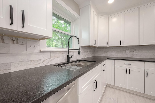 kitchen with dishwasher, sink, light tile patterned flooring, backsplash, and white cabinets