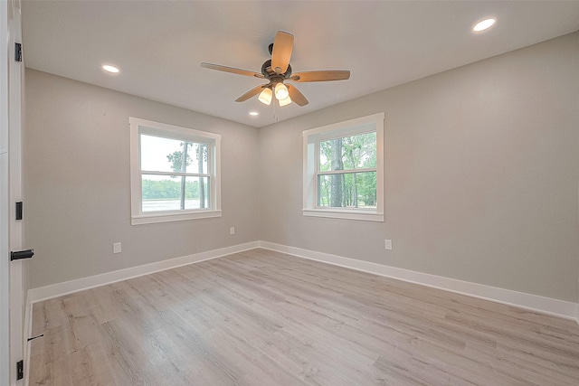 spare room featuring a wealth of natural light, ceiling fan, and light hardwood / wood-style floors