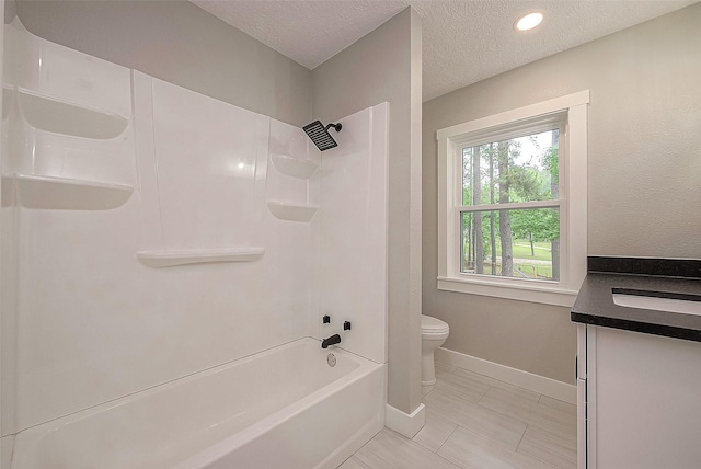 full bathroom featuring vanity, shower / bathtub combination, toilet, and a textured ceiling