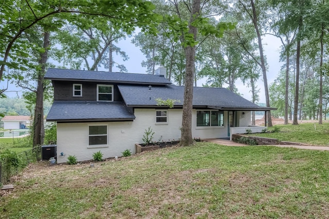 rear view of house with a lawn and central air condition unit