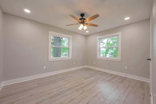 unfurnished room with plenty of natural light, ceiling fan, and light wood-type flooring