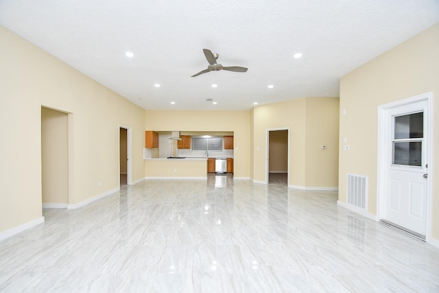 unfurnished living room featuring a textured ceiling and ceiling fan