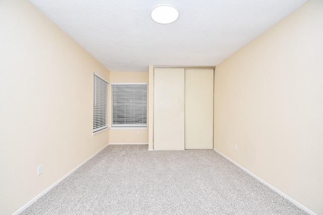 unfurnished bedroom featuring light carpet and a closet