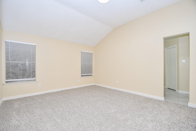 unfurnished room featuring light carpet and vaulted ceiling