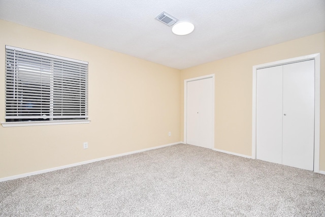 unfurnished bedroom featuring carpet flooring and a textured ceiling