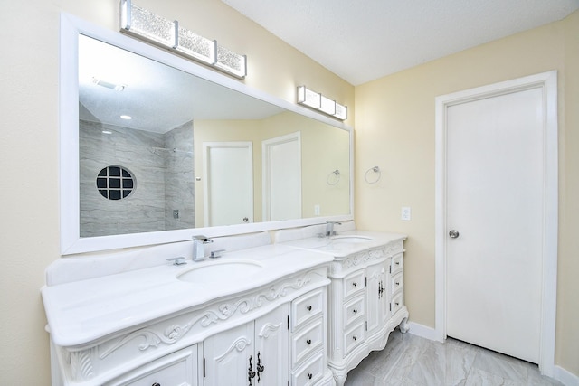 bathroom featuring a tile shower and vanity