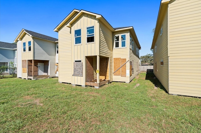 rear view of property featuring a lawn