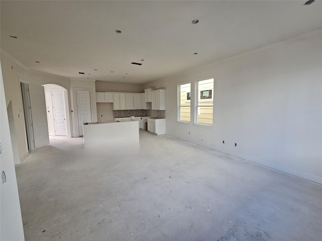 unfurnished living room with crown molding