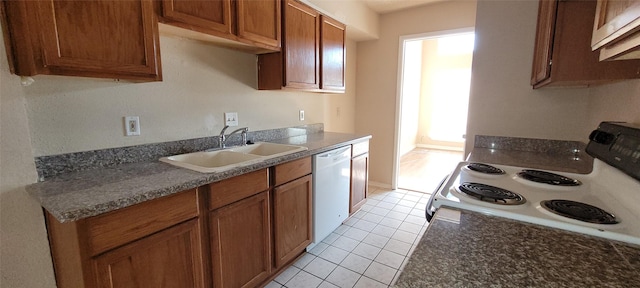 kitchen featuring light tile patterned floors, white appliances, and sink