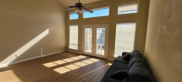 doorway with ceiling fan, wood-type flooring, a towering ceiling, and french doors