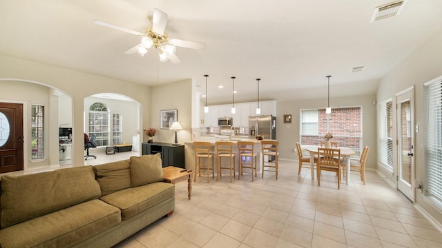 tiled living room featuring a wealth of natural light and ceiling fan