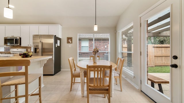 dining area with lofted ceiling and light tile patterned floors