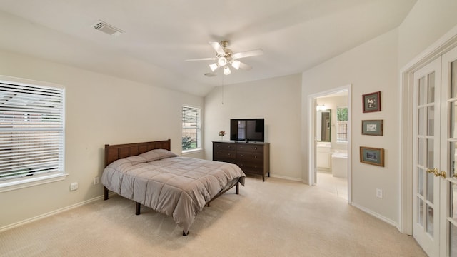 bedroom with light carpet, connected bathroom, ceiling fan, and lofted ceiling