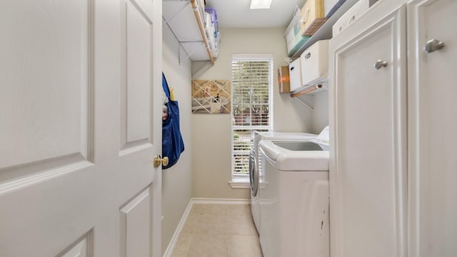 laundry area with washing machine and clothes dryer, plenty of natural light, and light tile patterned floors