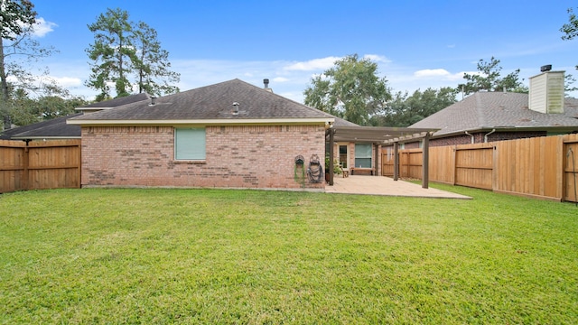 back of house with a yard and a patio