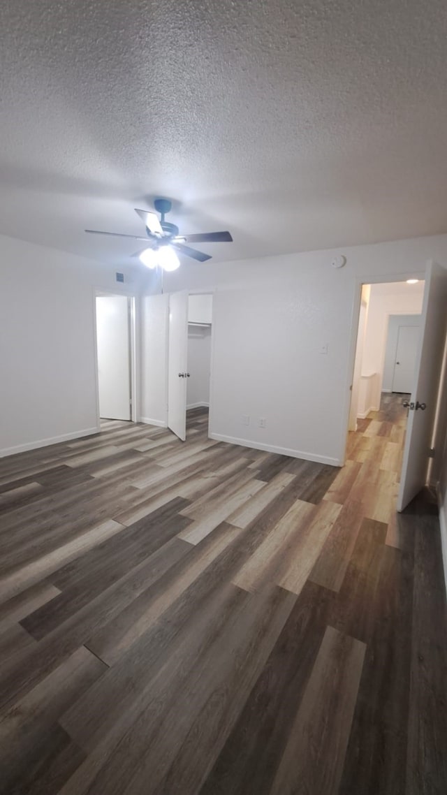 unfurnished room featuring ceiling fan, dark hardwood / wood-style floors, and a textured ceiling