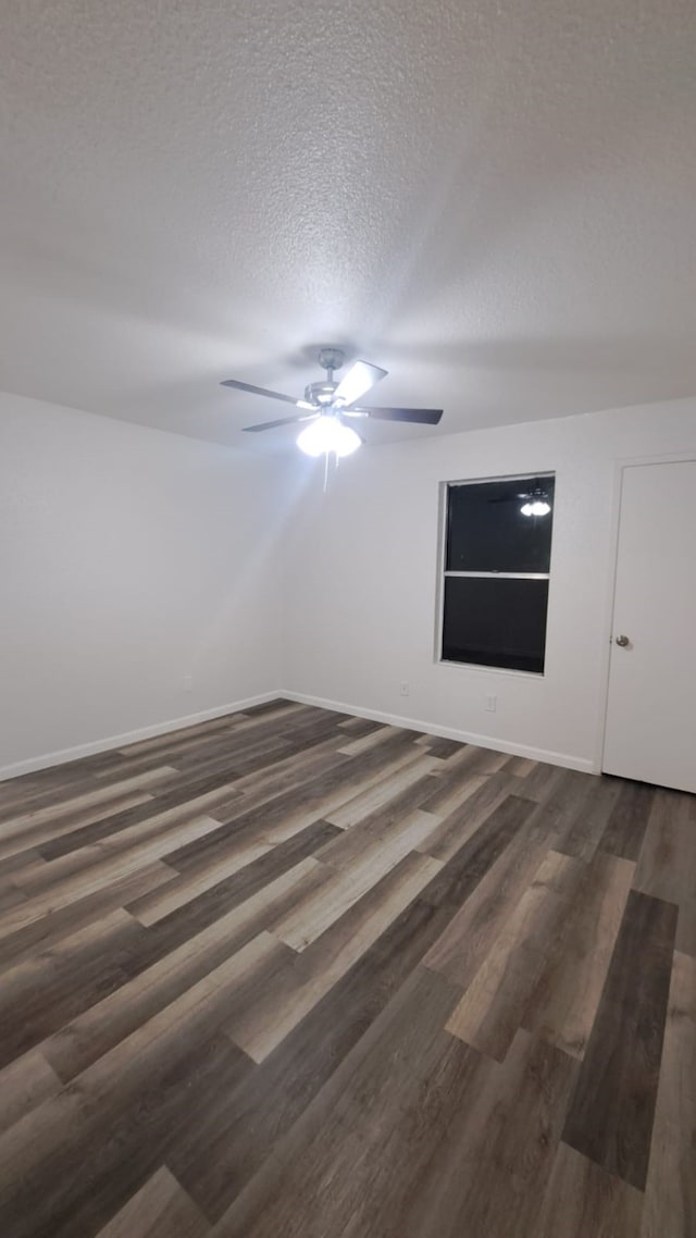 spare room with ceiling fan, dark hardwood / wood-style flooring, and a textured ceiling