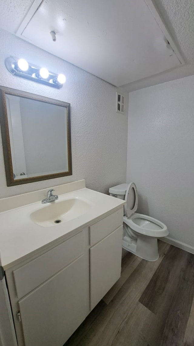 bathroom with vanity, hardwood / wood-style flooring, and toilet