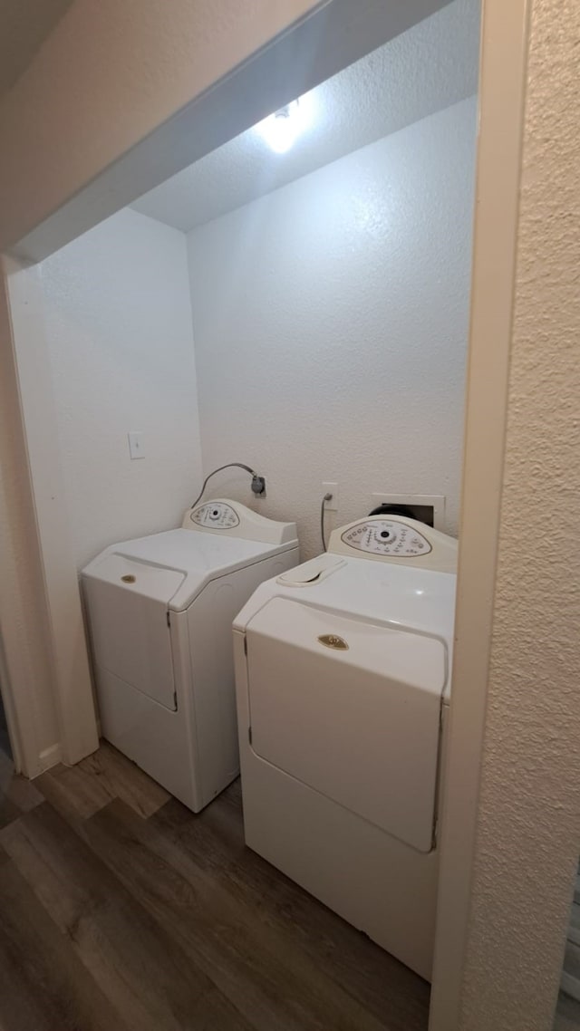 clothes washing area with independent washer and dryer and dark wood-type flooring