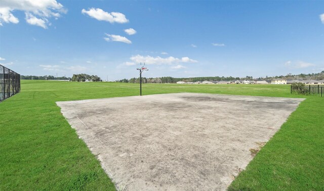 surrounding community featuring a yard and basketball hoop