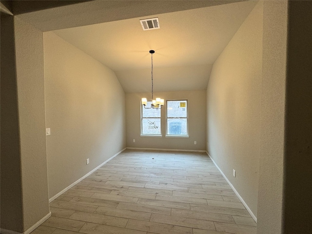 unfurnished dining area featuring light hardwood / wood-style floors, lofted ceiling, and a chandelier