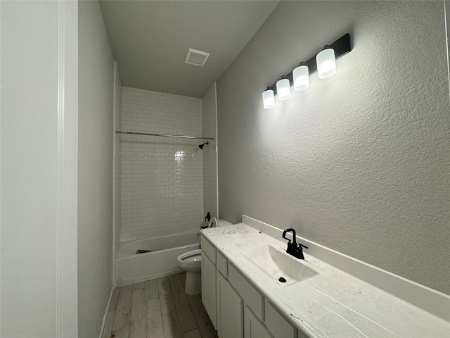 full bathroom with vanity, hardwood / wood-style flooring, toilet, and tiled shower / bath