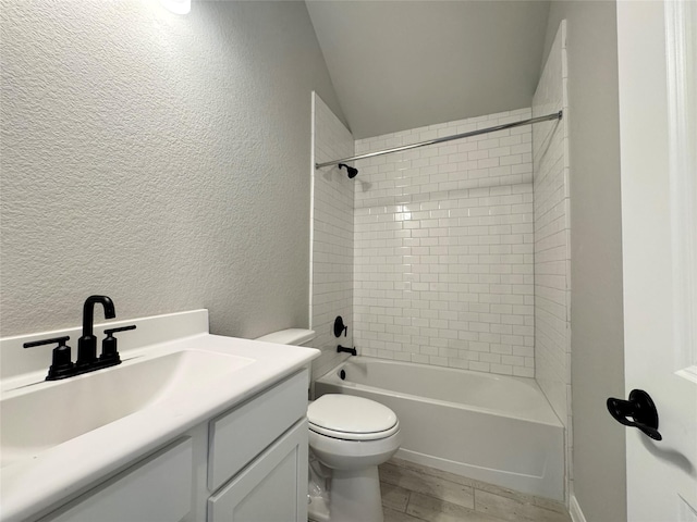 full bathroom with hardwood / wood-style flooring, vanity, tiled shower / bath combo, and toilet