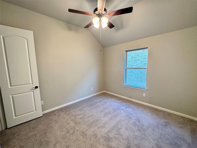 spare room featuring ceiling fan, light colored carpet, and vaulted ceiling