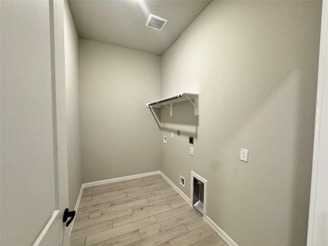 clothes washing area featuring gas dryer hookup, electric dryer hookup, washer hookup, and light wood-type flooring