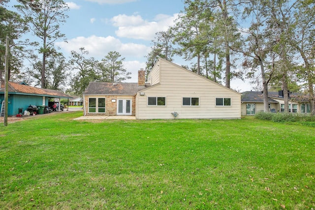 rear view of property with french doors and a lawn