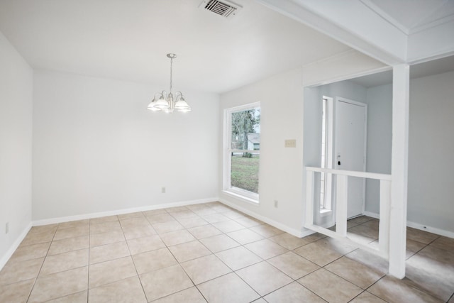 unfurnished room with a notable chandelier and light tile patterned flooring