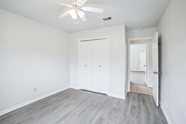 unfurnished bedroom with a closet, light hardwood / wood-style floors, and ceiling fan