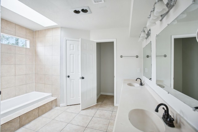 bathroom with a skylight, tile patterned flooring, and vanity