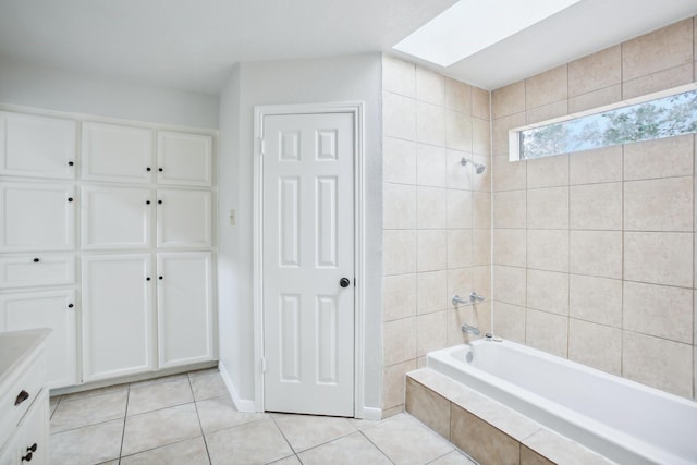 bathroom with tile patterned floors, tiled shower / bath, and a skylight