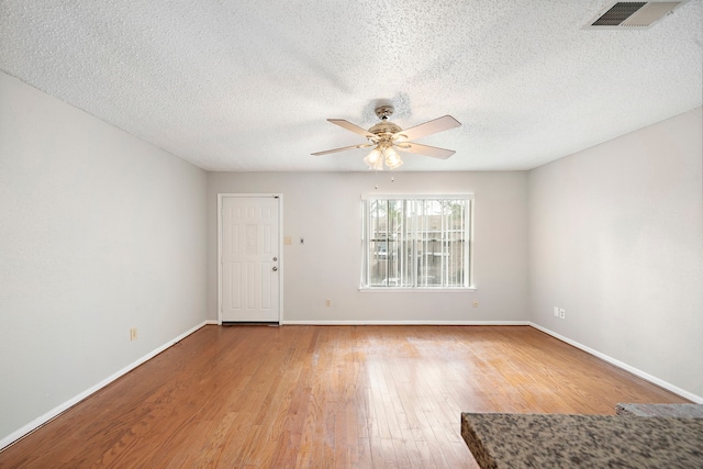 unfurnished room with wood-type flooring, a textured ceiling, and ceiling fan