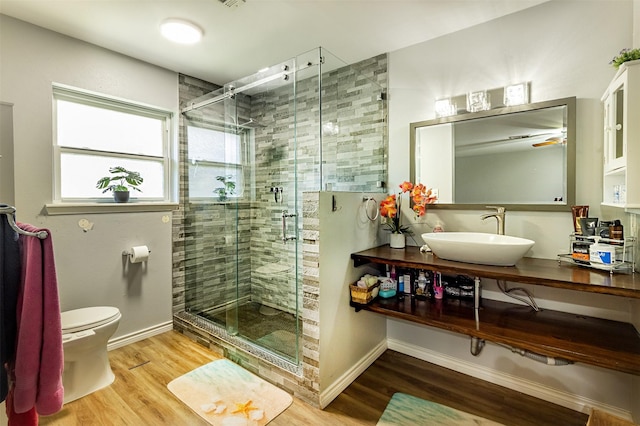 bathroom with wood-type flooring, vanity, toilet, and an enclosed shower