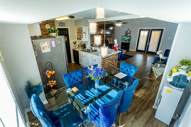 dining space with a wealth of natural light, sink, dark wood-type flooring, and vaulted ceiling