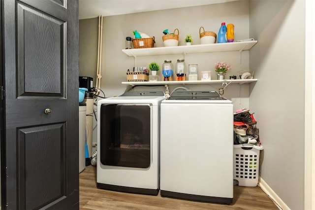 laundry area with washer and dryer and light hardwood / wood-style floors