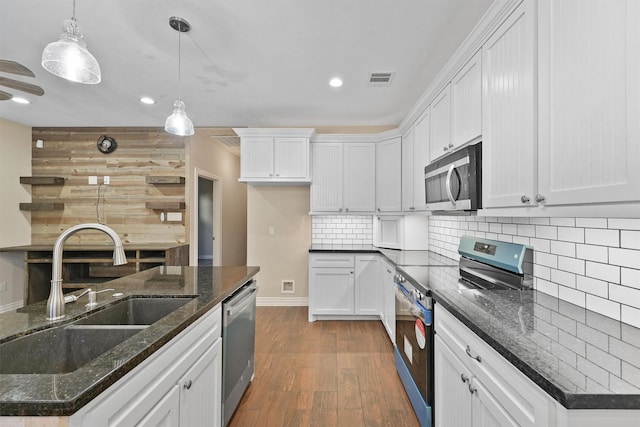 kitchen with hanging light fixtures, white cabinetry, sink, and stainless steel appliances